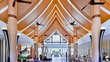 Eine großzügige Lobby mit hohen Decken, stattlichen Säulen und Deckenventilatoren.
