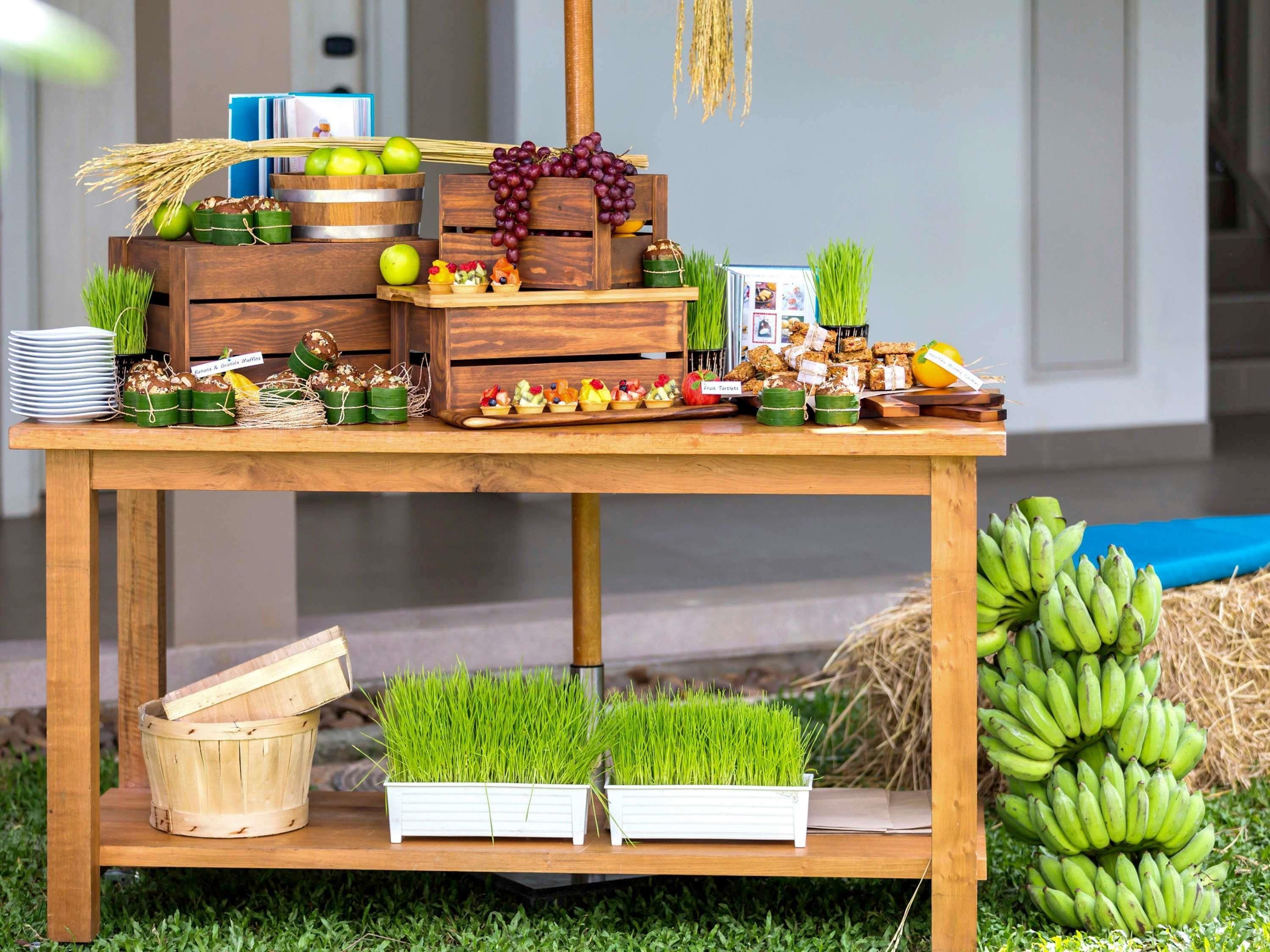 A wooden table with various food items, including fruits, vegetables, and packaged goods.