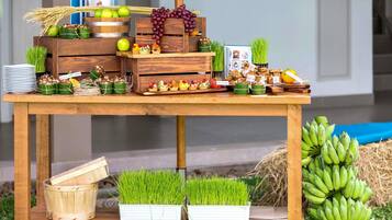 A wooden table with various food items, including fruits, vegetables, and packaged goods.