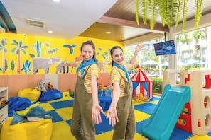 A play area with colorful murals, a slide, and various toys.
