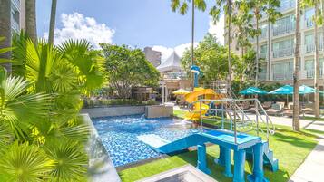 Relax by the pool surrounded by palm trees and enjoy a refreshing swim or slide down the water feature.