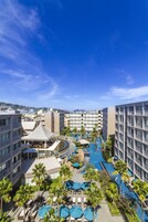 A hotel with multiple floors, a swimming pool, and outdoor seating areas.