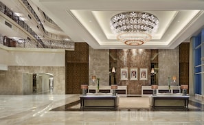 A spacious lobby with a grand chandelier, marble walls, and a high ceiling. - Waldorf Astoria Dubai Palm Jumeirah (Dubai)