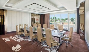 A conference room with a large table, multiple chairs, and a view of palm trees through large windows. - Waldorf Astoria Dubai Palm Jumeirah (Dubai)