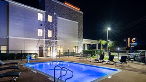Ein Hotel mit Swimmingpool, Außenbereich und einem Comfort Inn Schild.