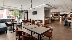 A modern restaurant with a mix of seating options, including tables and booths, and a visible kitchen area. - Hyatt Place Bloomington (Bloomington)