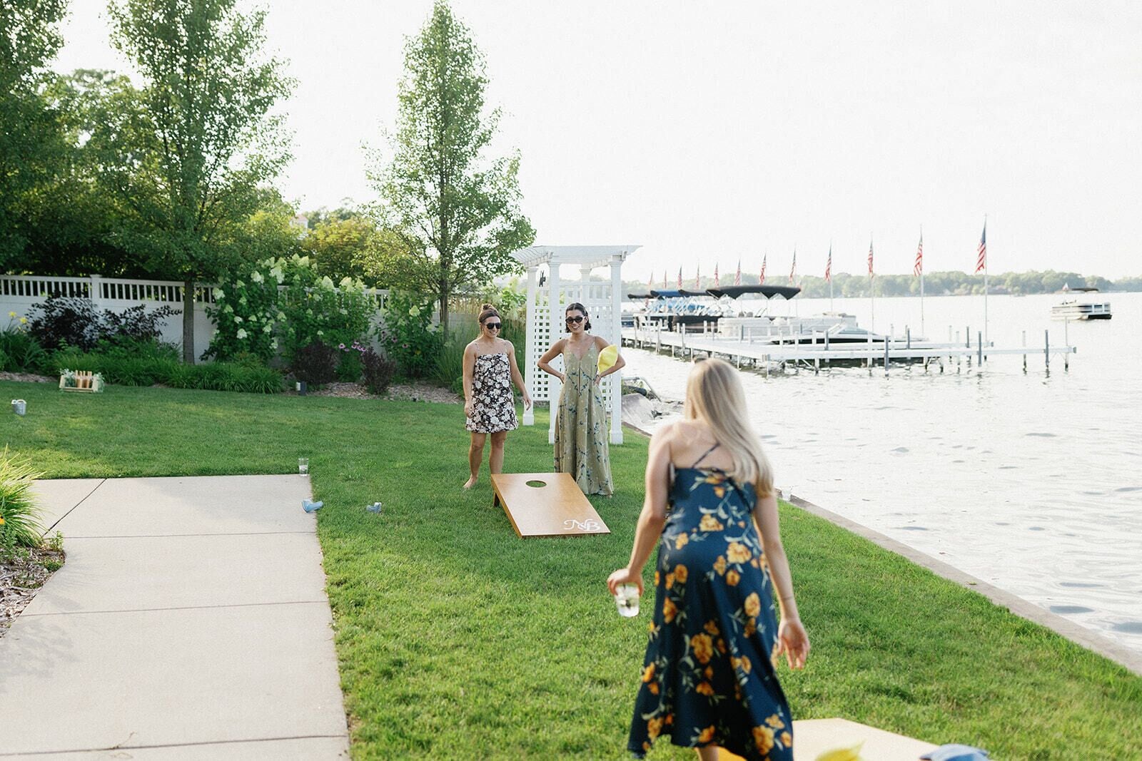 A grassy area with a wooden deck and a body of water in the background.