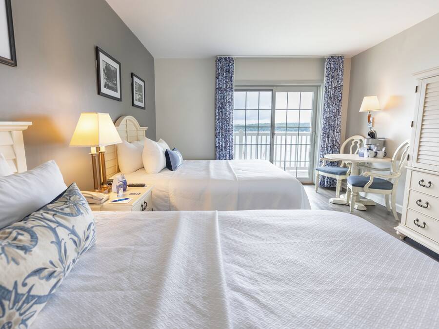 Een hotelkamer met twee bedden, een bureau, een stoel en een kledingkast.