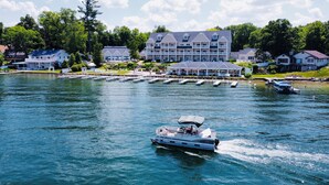 Un hôtel situé au bord d’un lac, doté d’un quai, de bateaux et d’un grand bâtiment comportant de nombreux balcons.