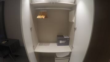 Un vestidor con una barra para colgar, una caja de almacenamiento y un estante.