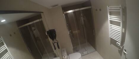 Un baño moderno con ducha, inodoro y tocador.