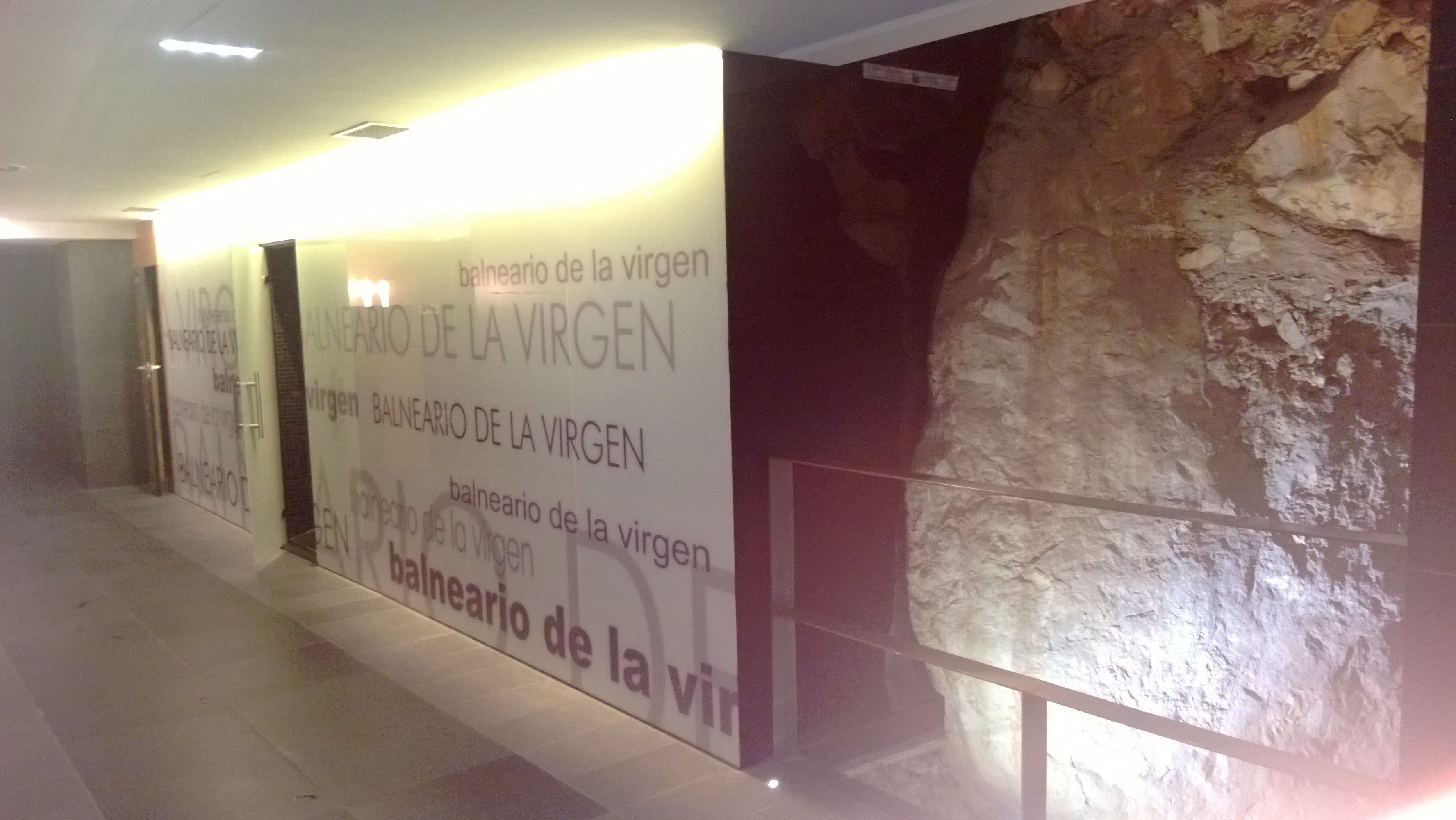 Un couloir dont un des murs est décoré à plusieurs reprises de l’inscription « balneario de la virgin ».
