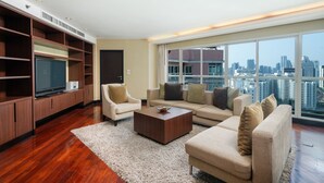 A modern living room with a large TV, a sofa set, and a coffee table. - The Narathiwas Hotel & Residence Sathorn Bangkok (Bangkok)