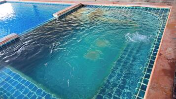 A swimming pool with clear blue water and a tiled edge.