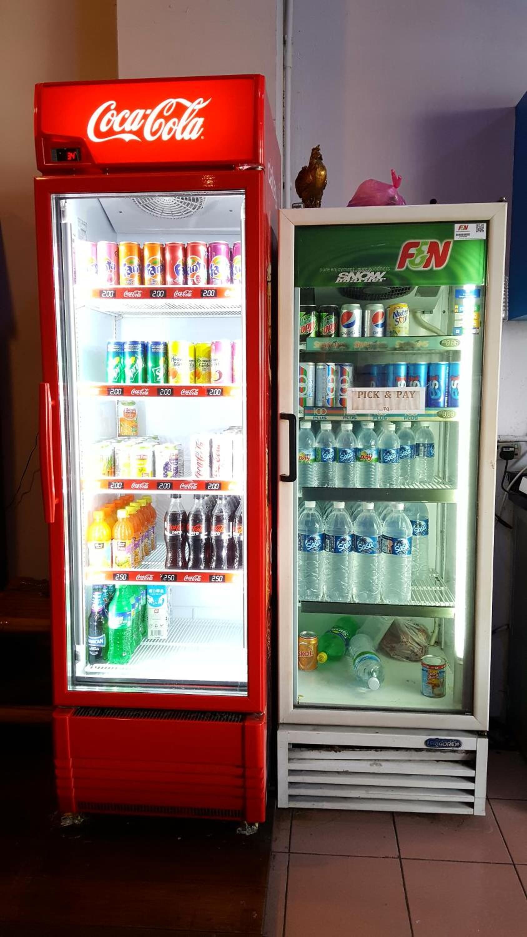 Deux distributeurs automatiques : l’un propose des produits Coca-Cola, l’autre, des boissons de la marque F.N.