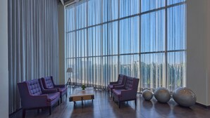 Un vestíbulo amplio con ventanas grandes, dos sofás, una mesa de centro y objetos esféricos decorativos.