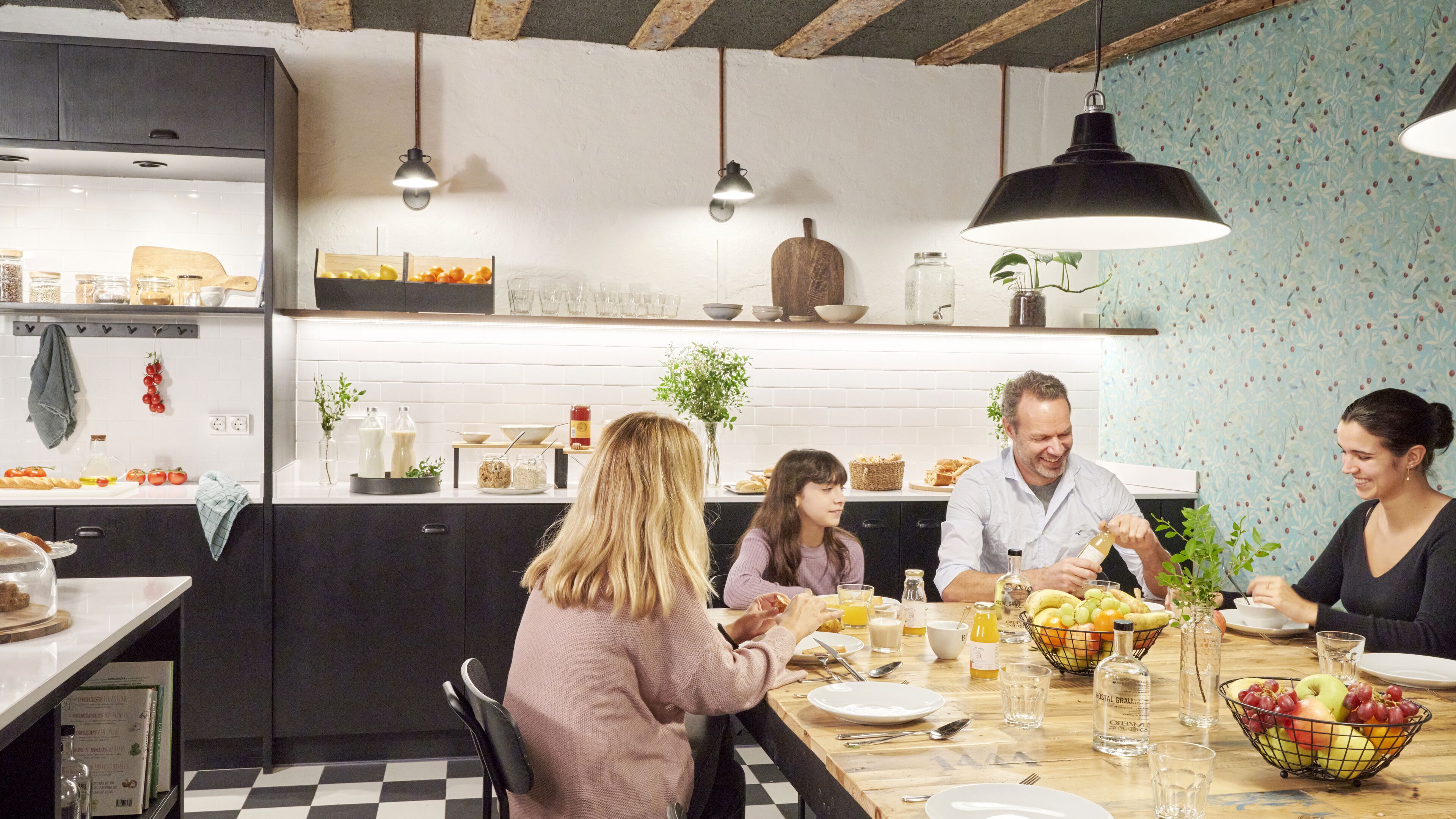 Una cocina moderna con piso a cuadros, armarios de madera e iluminación colgante.