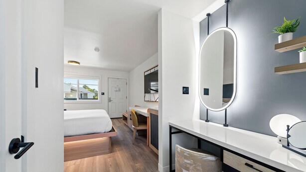A modern bedroom with a bed, a desk, and a large mirror. -  GoodSpring Motel (Napa)