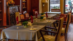 A dining area with tables set for a meal, chairs, and a lamp. - Ramada by Wyndham Bishkek Centre (Bishkek)