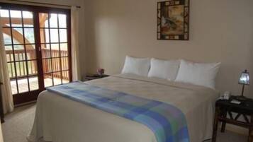 Un dormitorio con una cama grande, una mesita de noche, una lámpara y un cuadro en la pared.