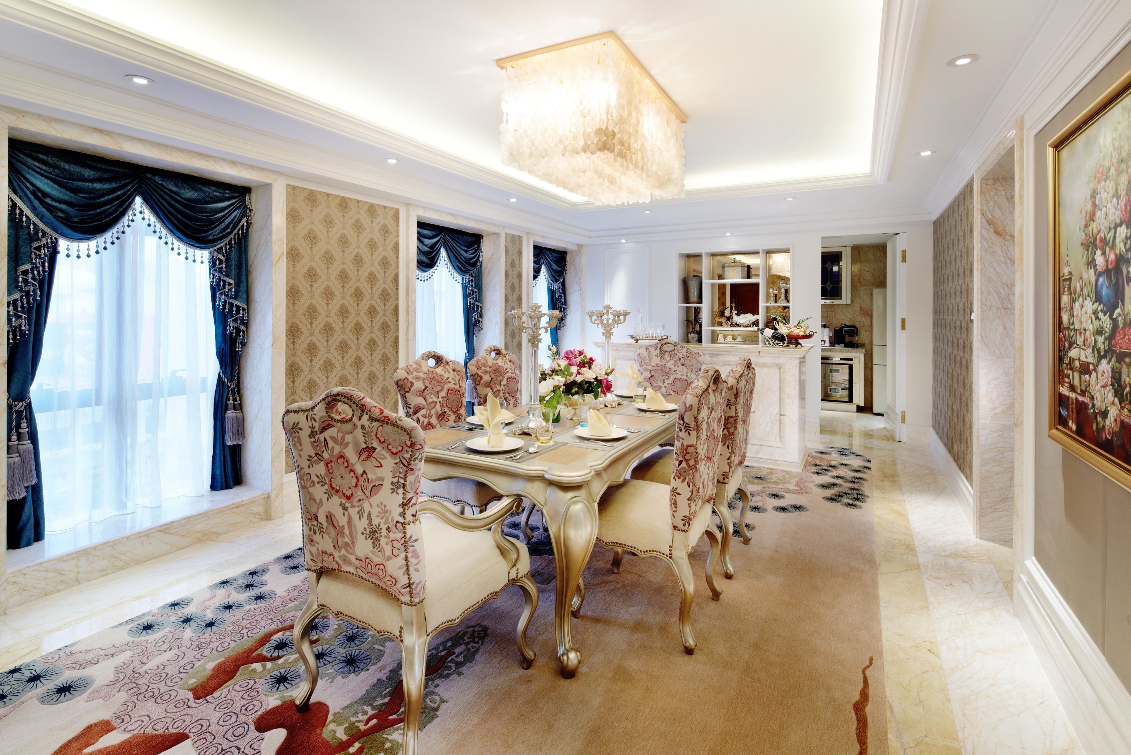 A dining room with a large table, ornate chairs, and a chandelier.