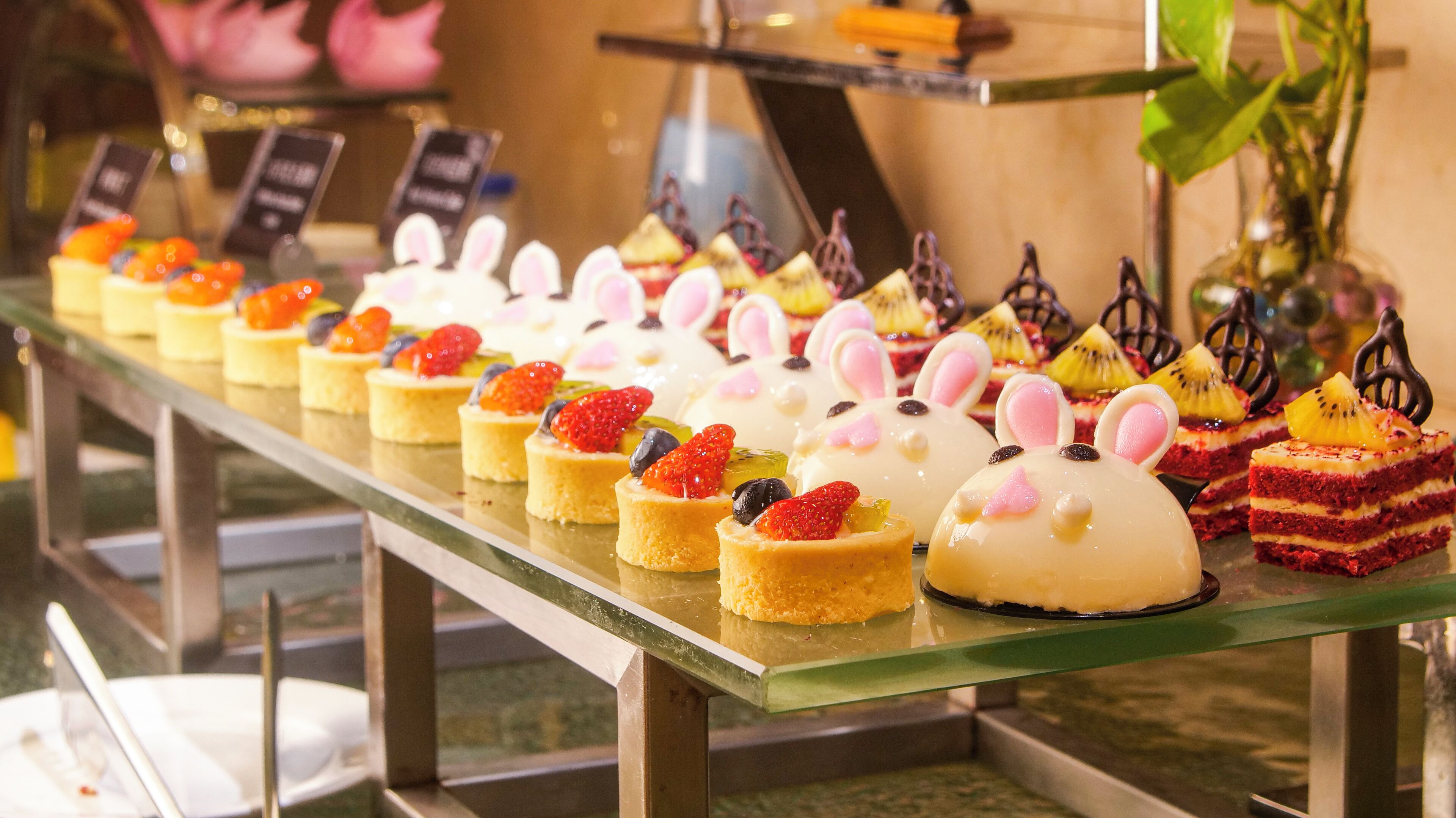 A variety of desserts displayed on a glass counter.
