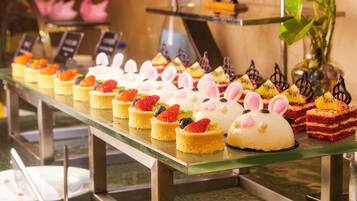 A variety of desserts displayed on a glass counter.