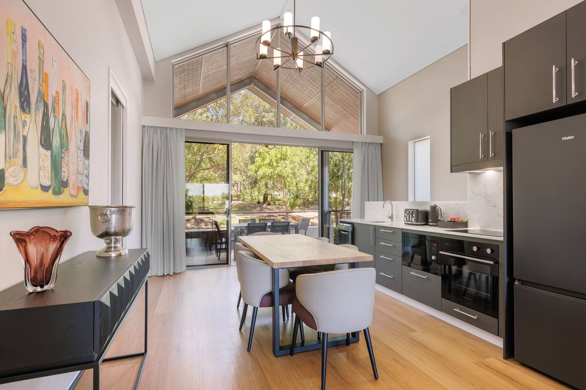 Una cocina moderna con comedor, ventanas amplias y vistas al exterior.
