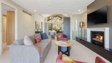 Relax in this stylish living room with a sofa set, coffee table, and armchair, perfect for unwinding in front of the flat-screen TV.