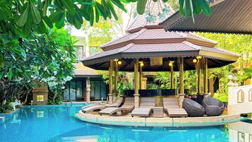 Una piscina al aire libre, camas de piscina gratis, sombrillas