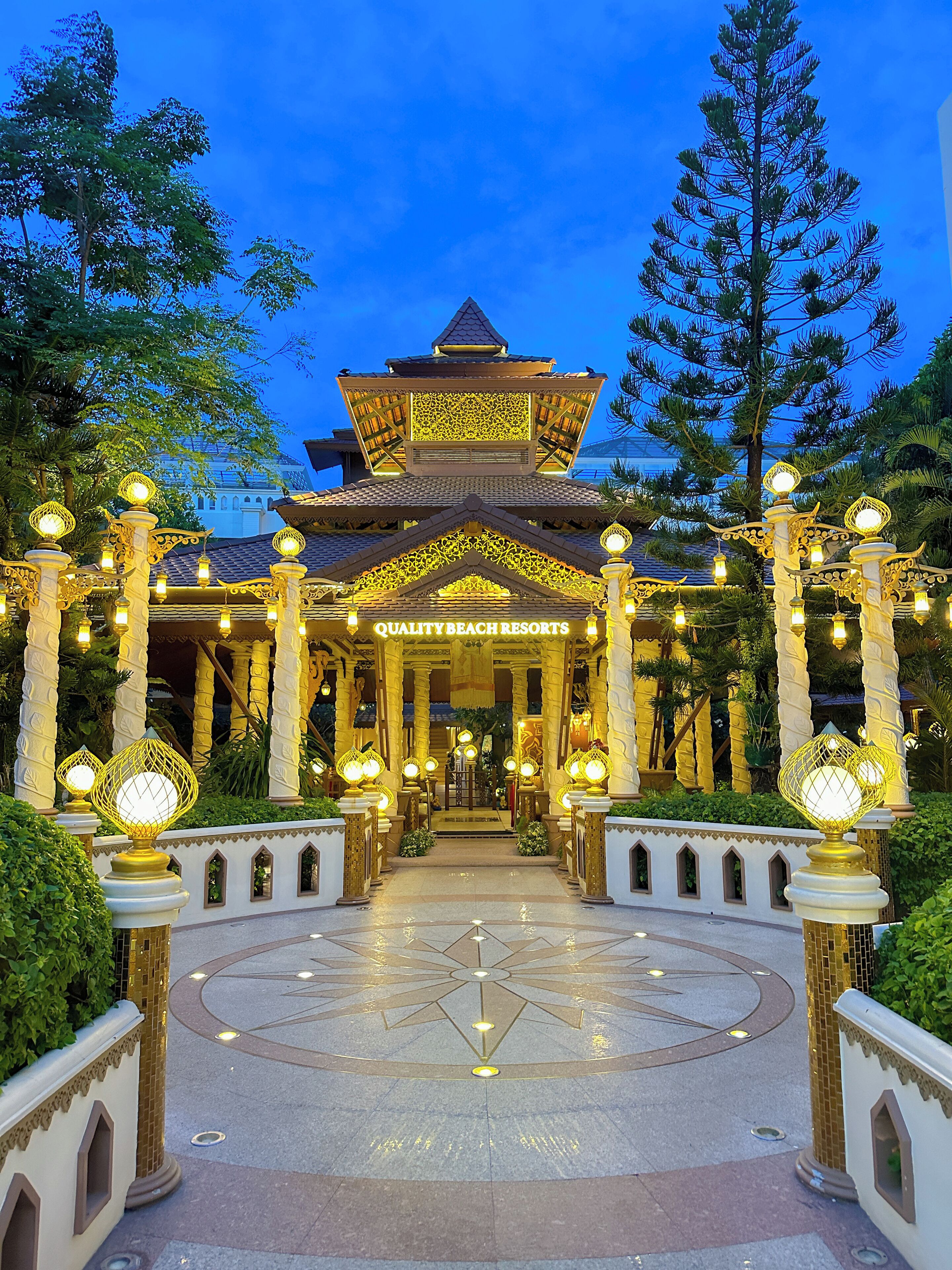 A traditional-style building with a central entrance, surrounded by ornate columns and decorative lighting.