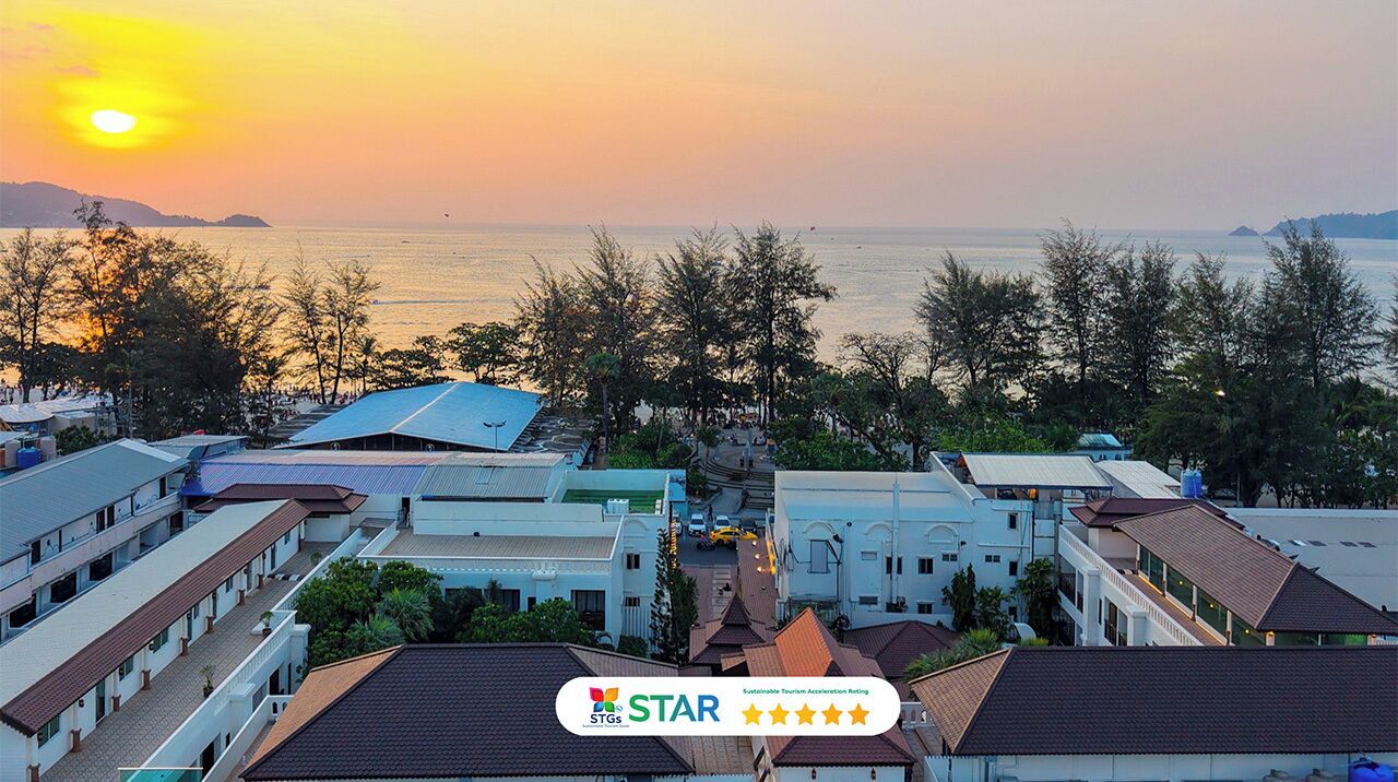 Um hotel à beira-mar com vários edifícios, vista para o mar e um pôr do sol.