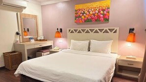 A hotel room with a large bed, a desk with a mirror, a telephone, and two bedside lamps. - Heritage Hotel (Tawau)