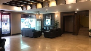 A spacious lobby with a high ceiling, a staircase, and a seating area with sofas. - Heritage Hotel (Tawau)