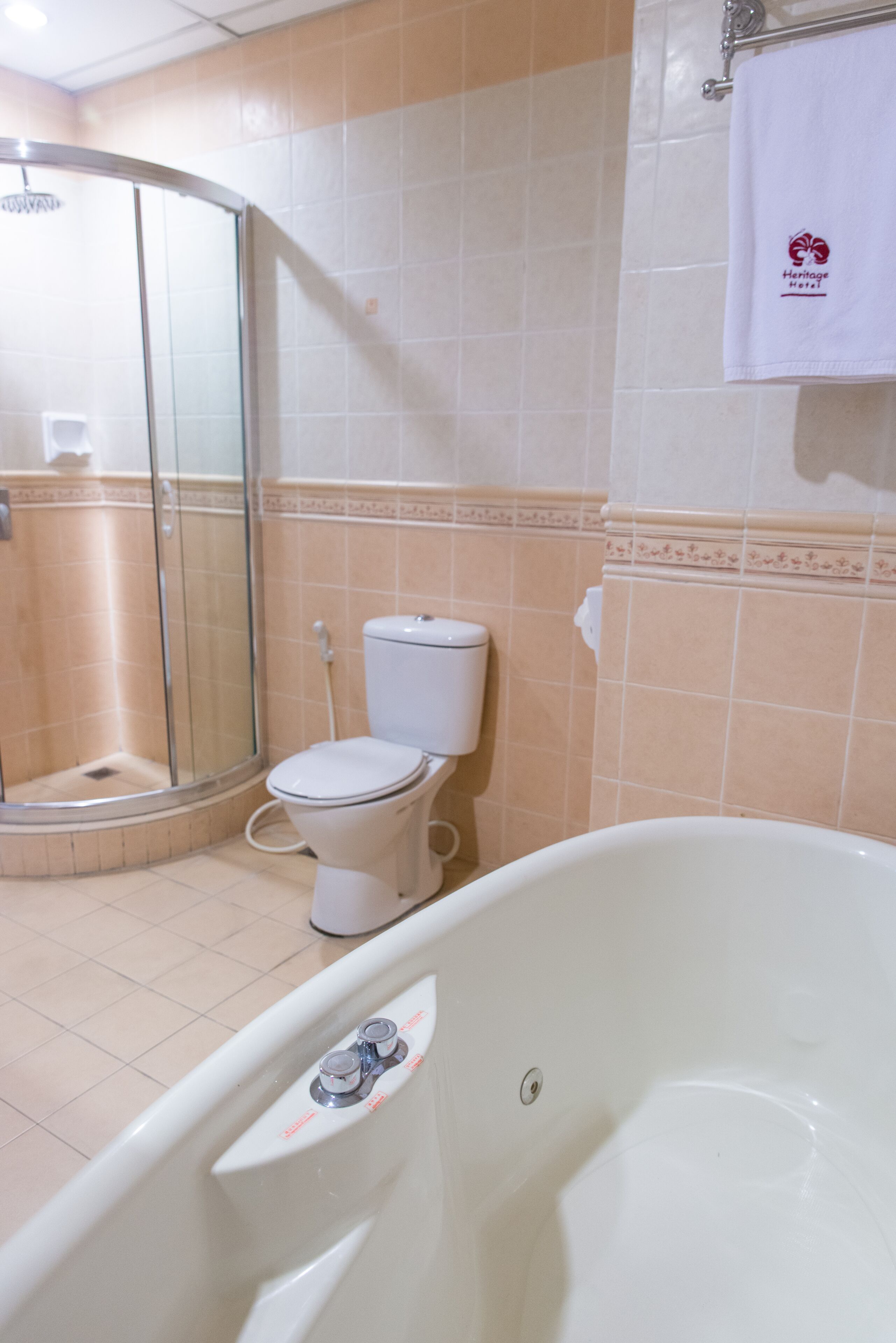 A bathroom with a glass-enclosed shower, a toilet, and a bathtub.