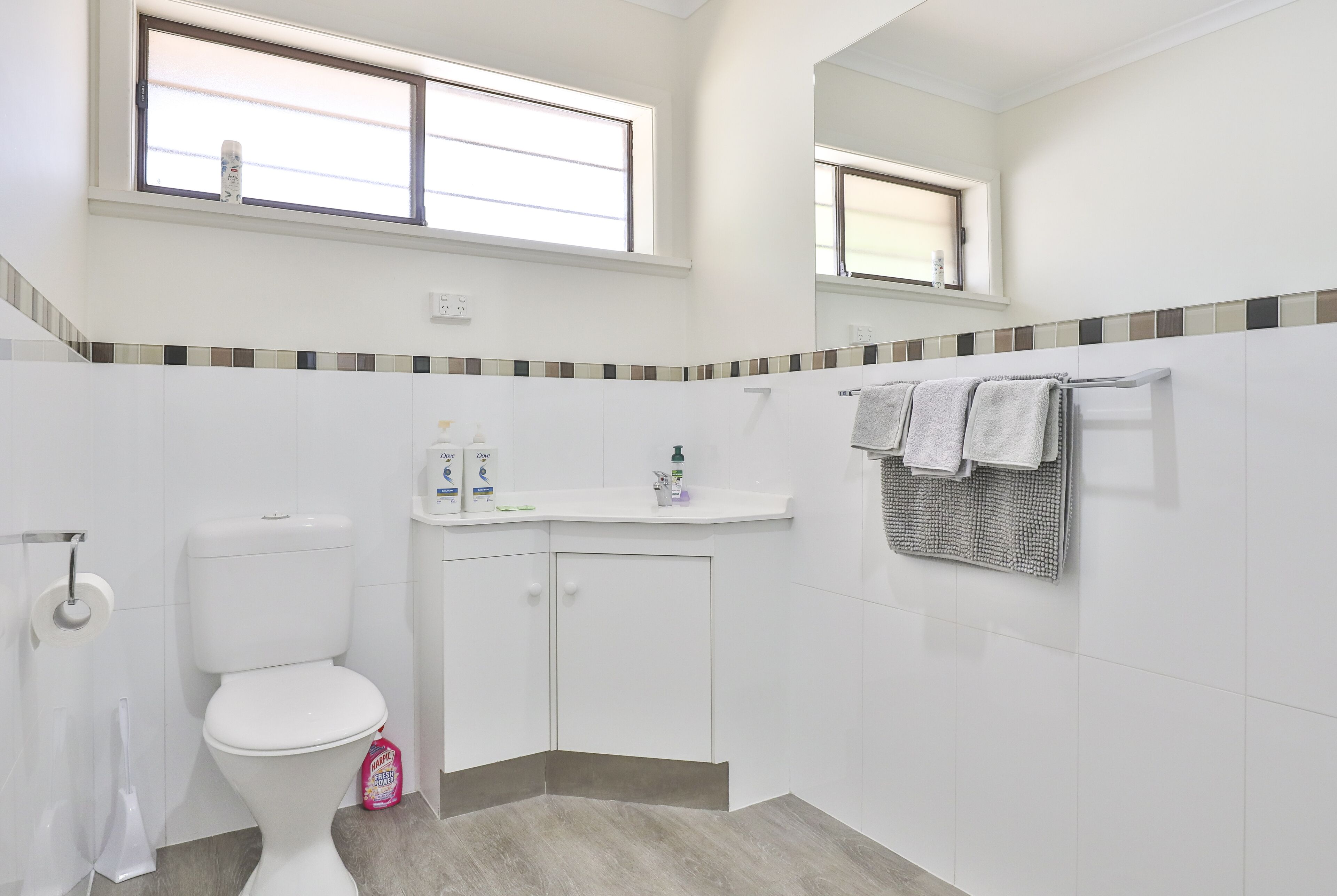 Ein Badezimmer mit Toilette, Waschbecken und Spiegel.