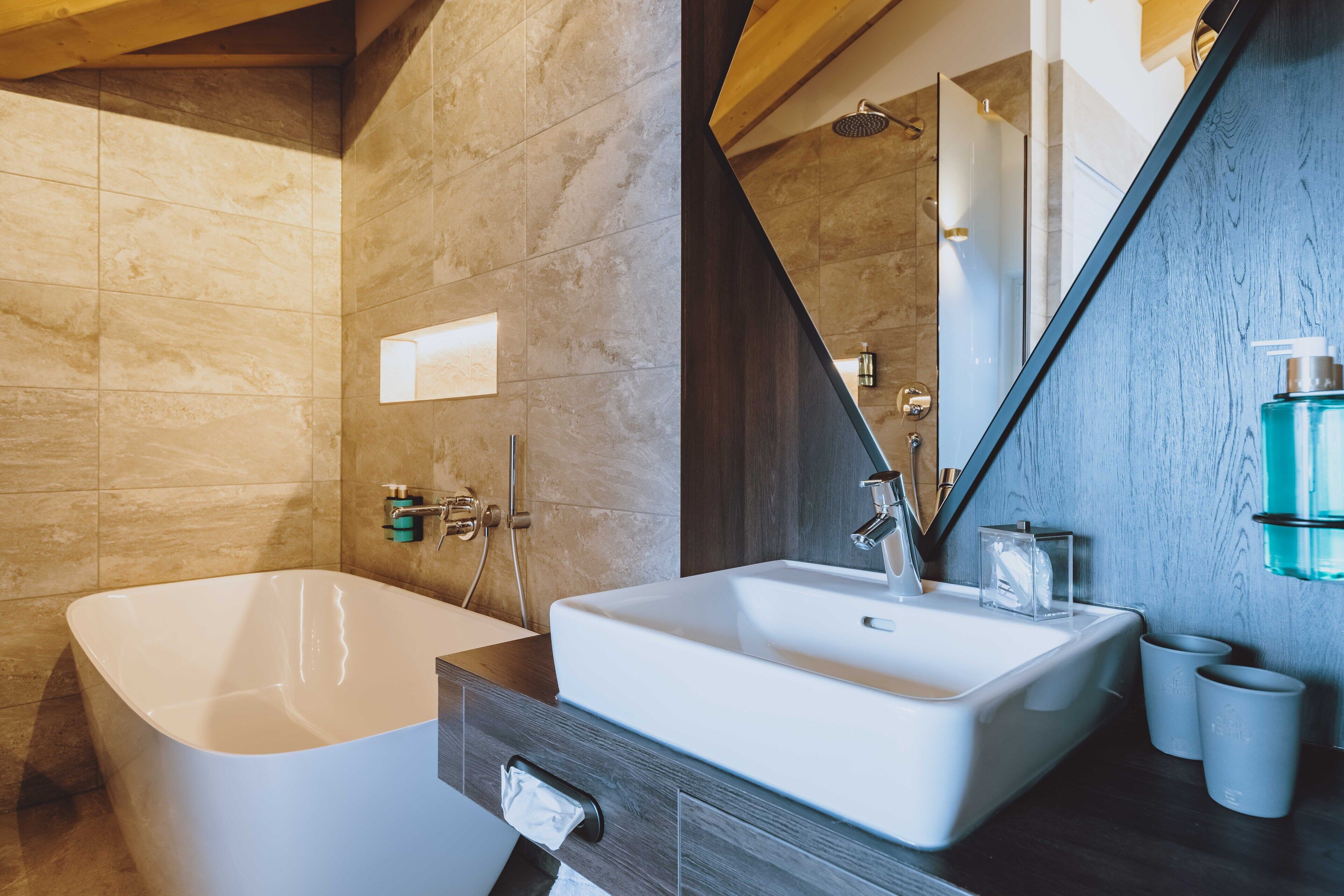 Une salle de bain moderne avec une baignoire sur pieds, un grand lavabo et un miroir.