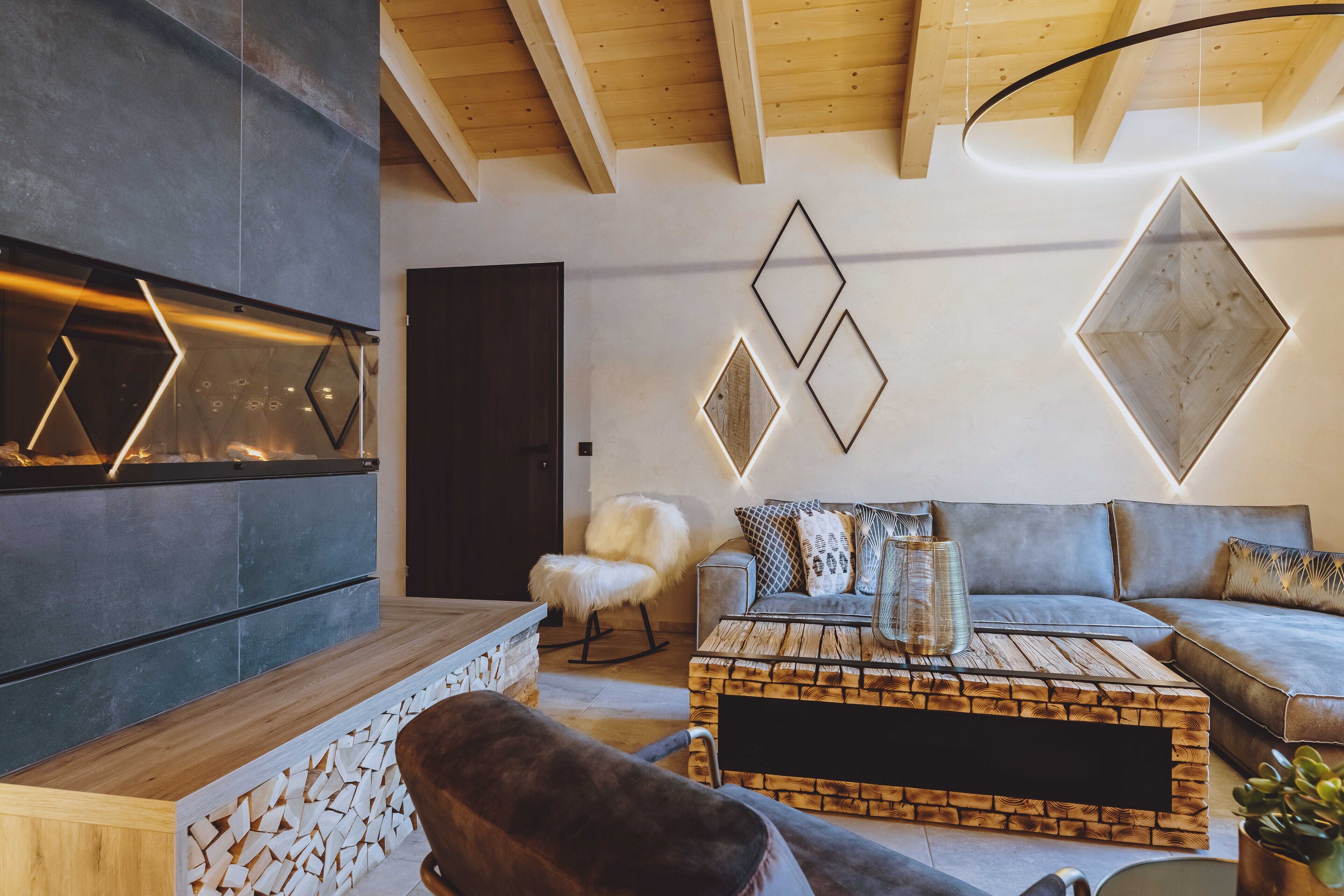 Una sala de estar moderna con chimenea, un sofá, una mesa de centro y decoración en la pared.