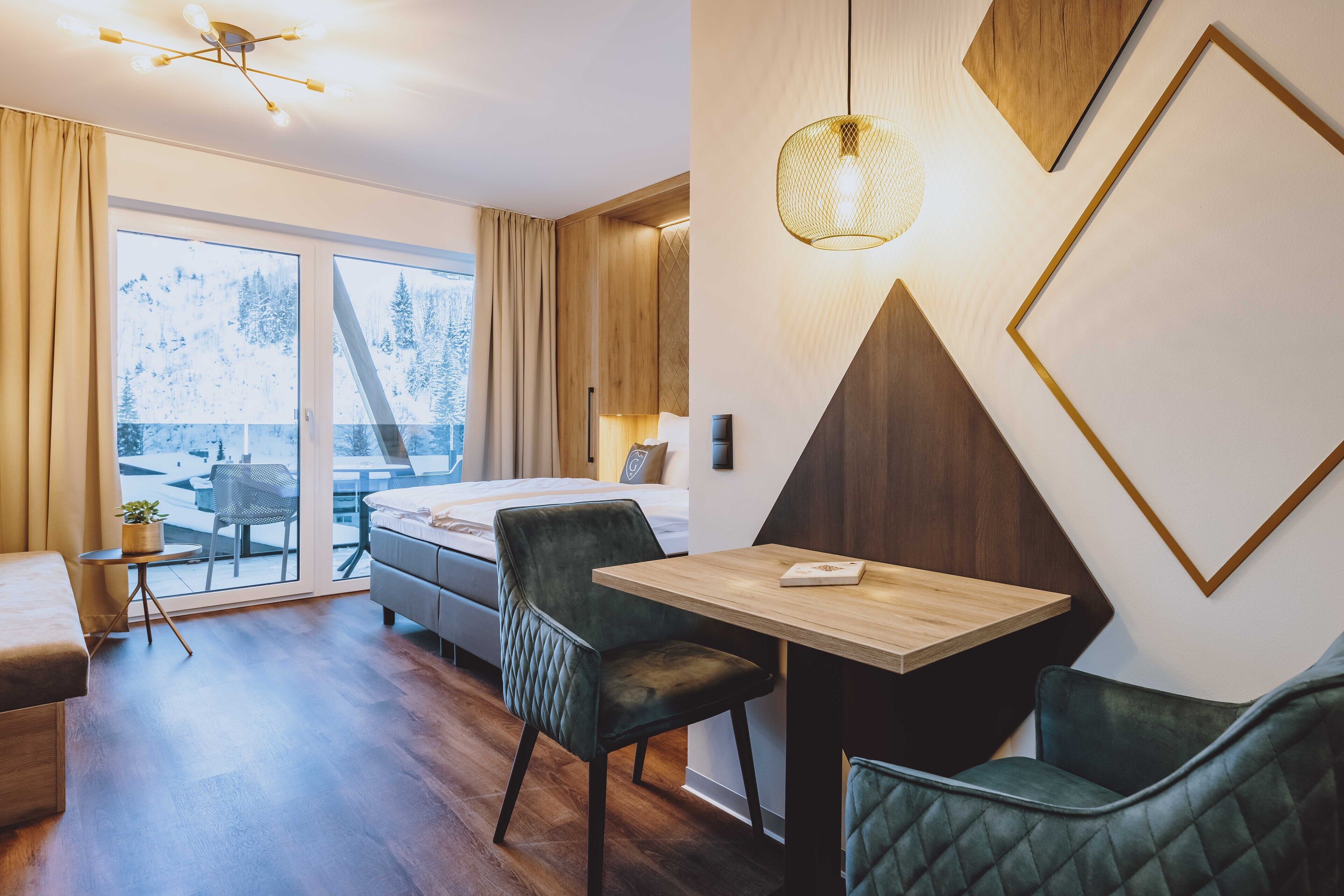 Une chambre d’hôtel moderne équipée d’un lit, d’une table à manger et d’un coin salon.