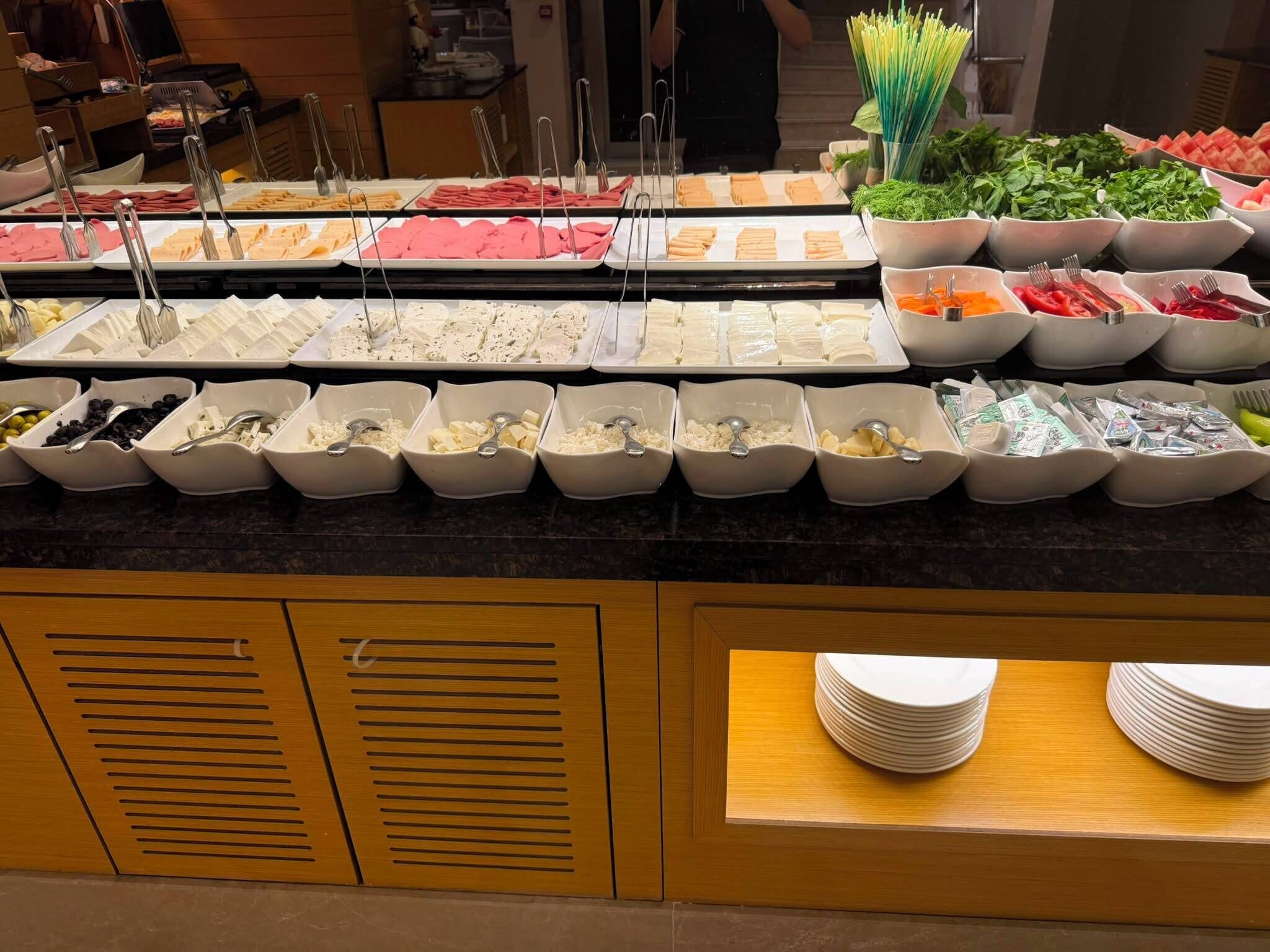 A buffet with various food items and utensils.