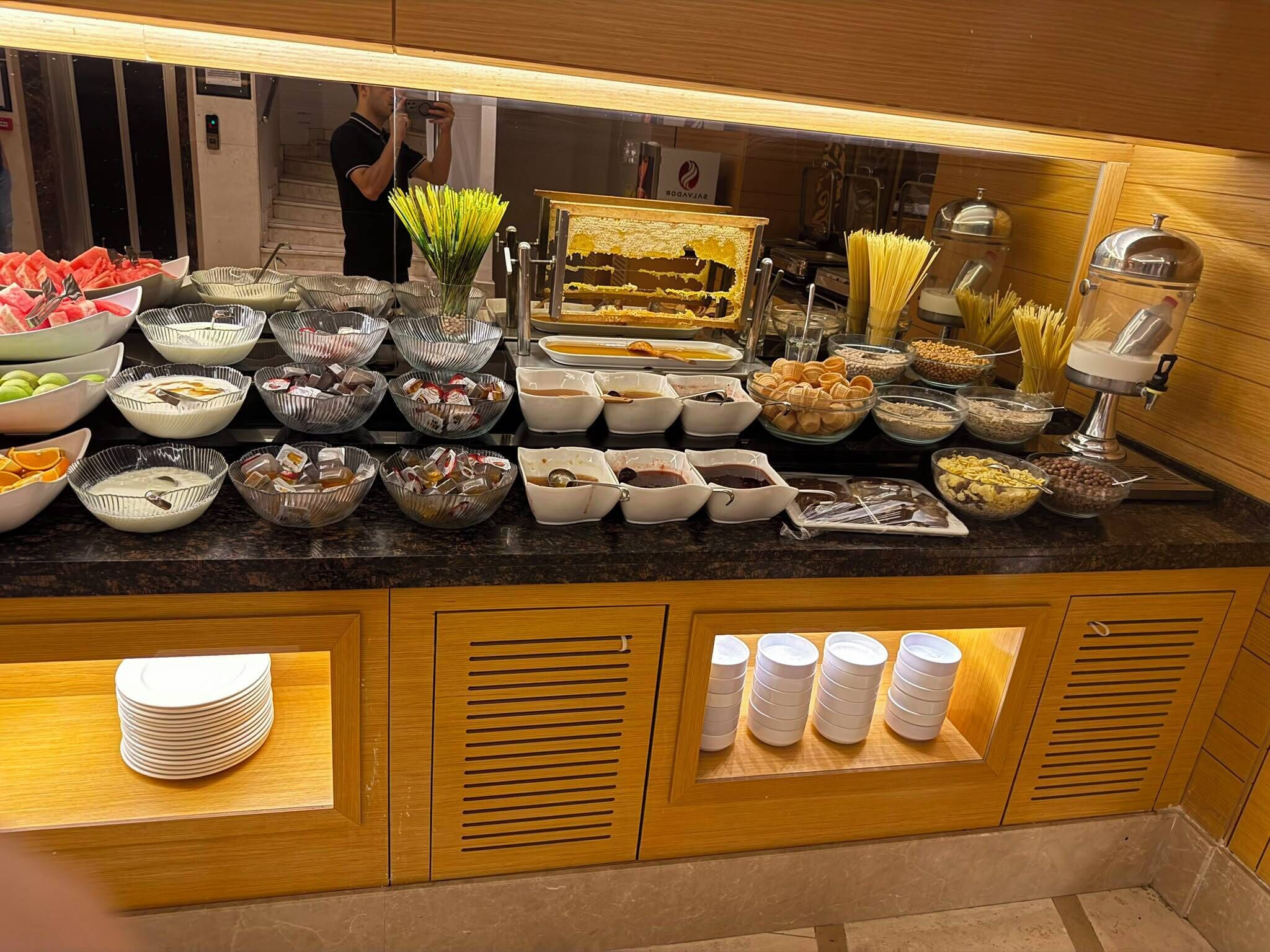A buffet setup with various food items and condiments.