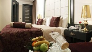 A hotel room with a bed, bedside table, lamp, and a fruit basket on the nightstand. - Mirilayon Hotel (Istanbul)