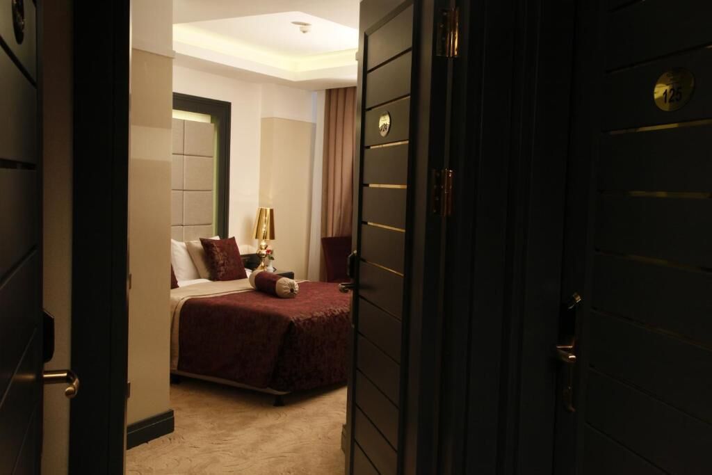 Une chambre d’hôtel avec un lit, une table de chevet et un grand miroir.