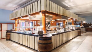 A buffet area with a wooden counter, labeled 'Gegrilltes' and 'Vorschiesen', featuring a variety of food items and a coffee machine. - Heide Park Holiday Camp (Soltau)