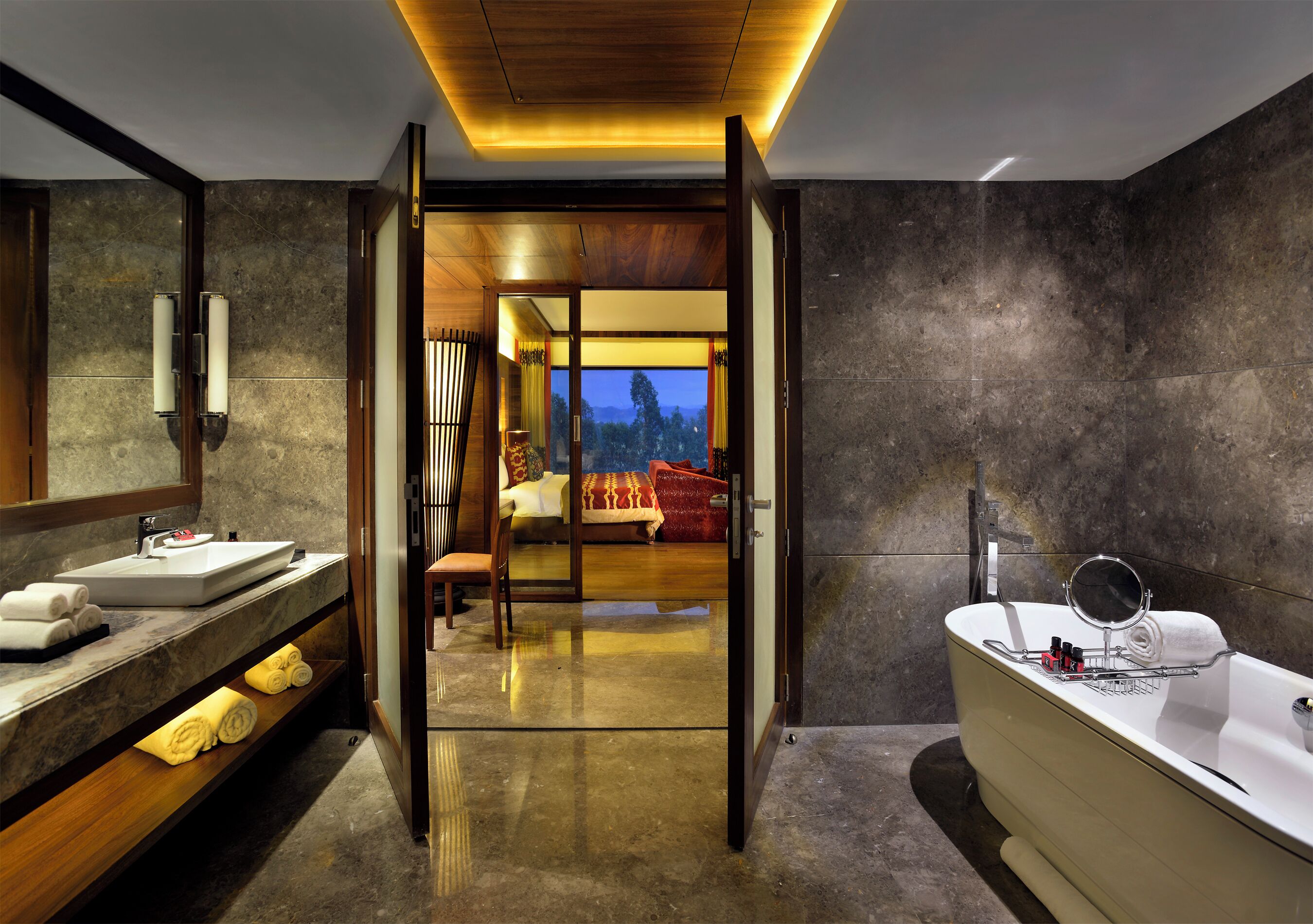 A modern bathroom with a bathtub, a vanity with a sink, and a mirror.