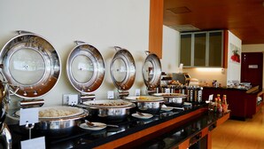 A buffet setup with multiple self-service food stations, including various dishes and condiments. - ZIA Hotel Kuta (Kuta)