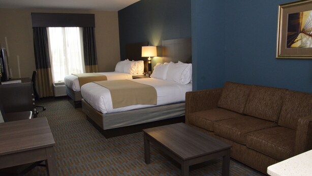 A hotel room with two beds, a sofa, a desk, and a TV. - Holiday Inn Express Hotel & Suites Goldsboro - Base Area by IHG (Goldsboro)