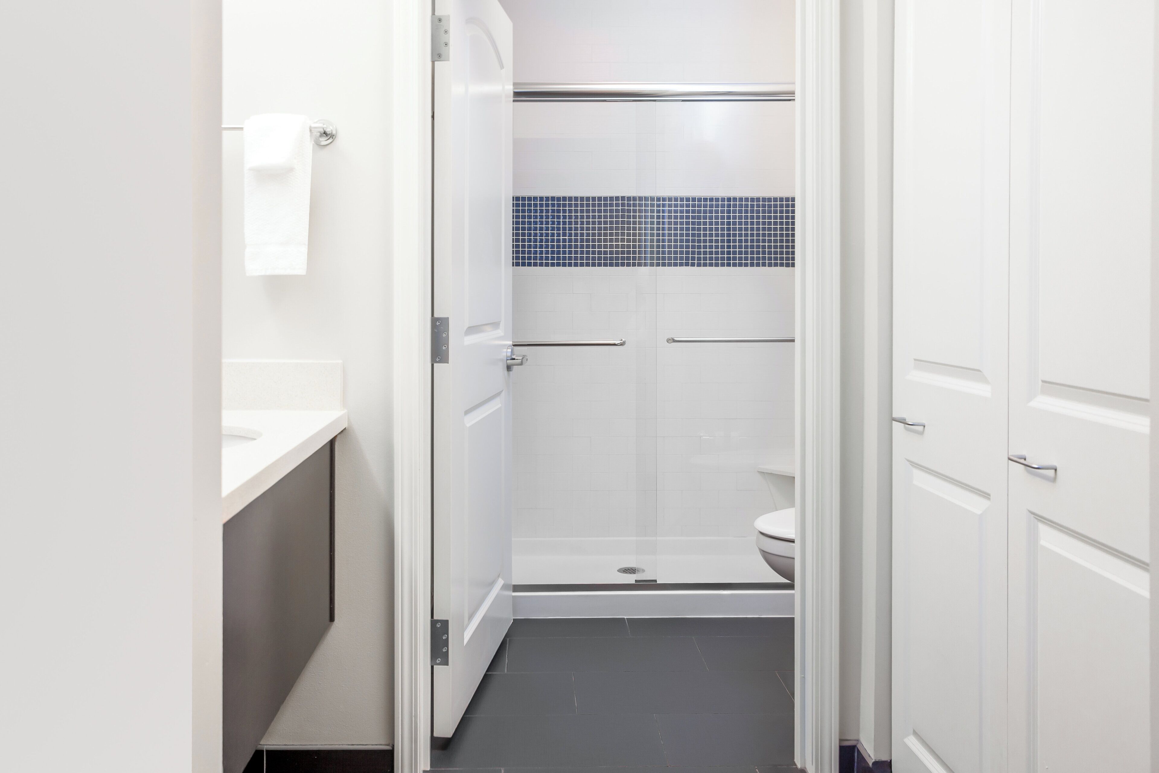 A bathroom with a white sink, a toilet, and a shower area.