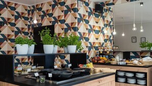 Una cocina moderna con paredes de diseño geométrico, una isla central con encimera negra y armarios de madera.
