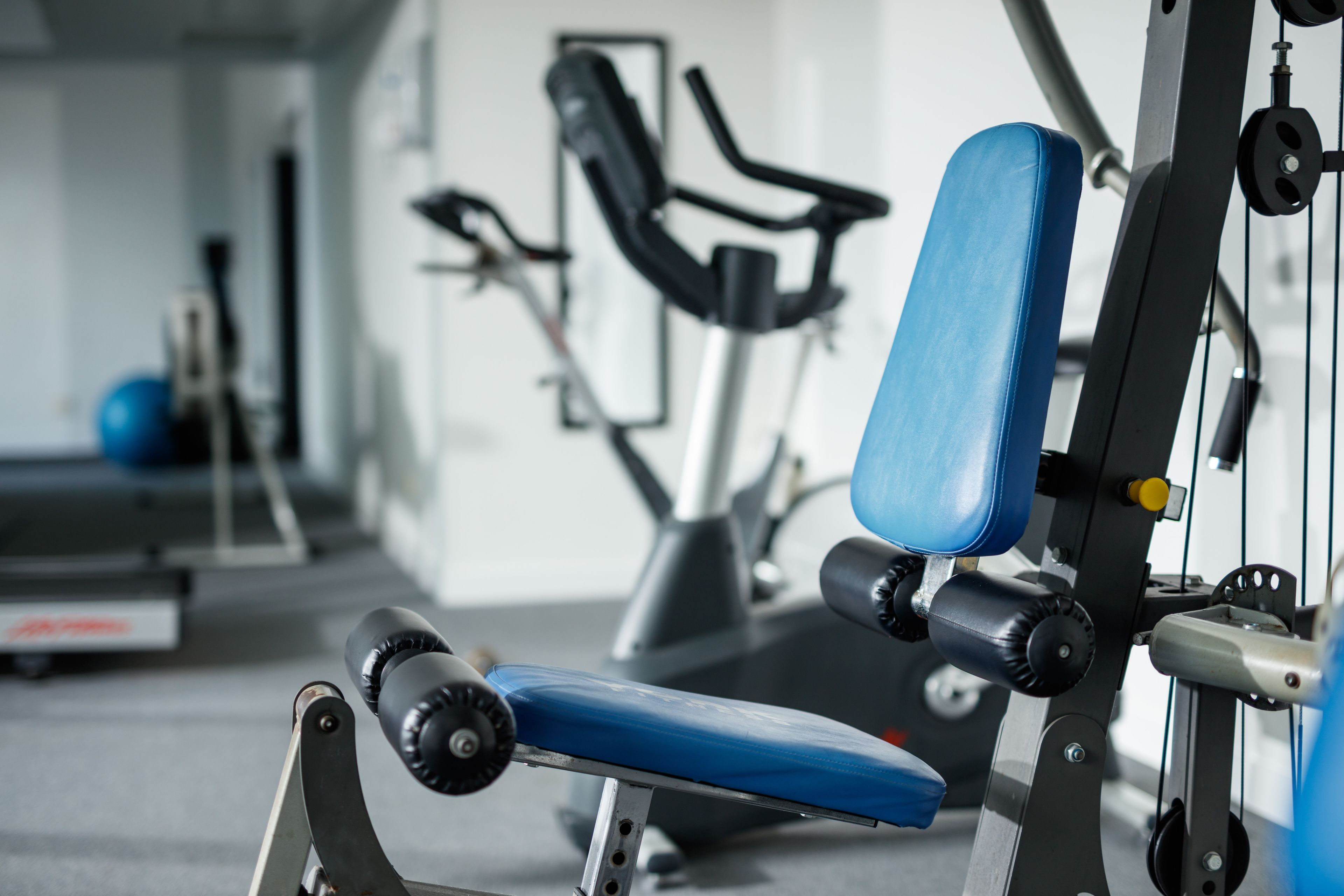A gym with exercise equipment, including a bench and a machine.